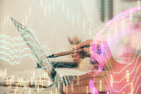 Multi exposure of woman hands typing on computer and financial graph hologram drawing. Stock market...