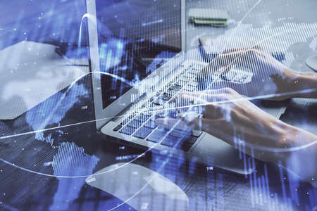 Double exposure of woman hands typing on computer and forex chart hologram drawing. Stock market...