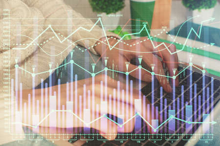 Double exposure of woman hands typing on computer and forex chart hologram drawing. Stock market invest concept.の写真素材