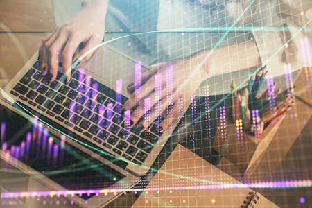 Double exposure of woman hands typing on computer and forex chart hologram drawing. Stock market...