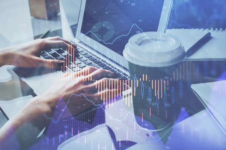 Double exposure of woman hands typing on computer and forex chart hologram drawing. Stock market...