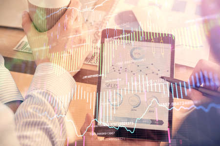 Double exposure of mans hands holding and using a phone and financial chart drawing. Market analysis...