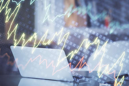 Stock market graph on background with desk and personal computer. Double exposure. Concept of...