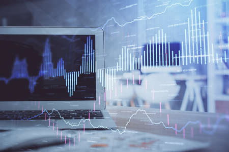 Forex market chart hologram and personal computer background. Double exposure. Concept of...