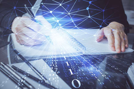 Double exposure of writing hands on background with data solution hologram on front. Technology...