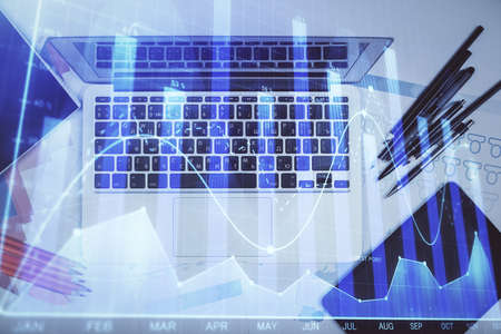 Multi exposure of forex chart drawing over table background with computer. Concept of financial...