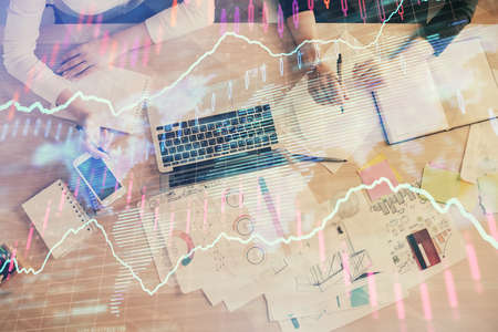 Double exposure of woman hands working on computer and forex graph hologram drawing. Top View....