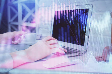 Double exposure of woman hands typing on computer and forex chart hologram drawing. Stock market...