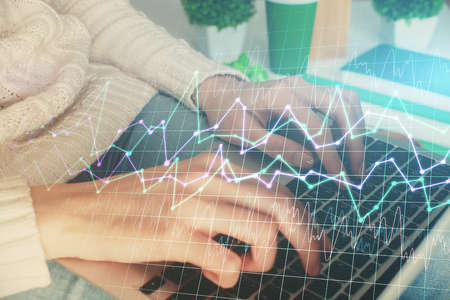 Double exposure of woman hands typing on computer and forex chart hologram drawing. Stock market invest concept.の写真素材