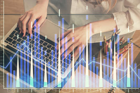 Double exposure of woman hands typing on computer and forex chart hologram drawing. Stock market...