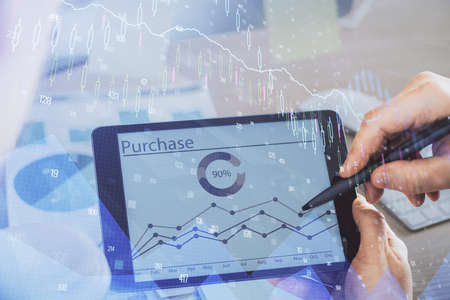 Double exposure of mans hands holding and using a phone and financial chart drawing. Market analysis...