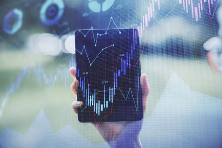 Double exposure of forex chart sketch hologram and woman holding and using a mobile device....