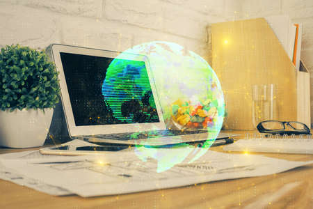 Computer on desktop with social network hologram. Multi exposure. Concept of international people connections.の写真素材