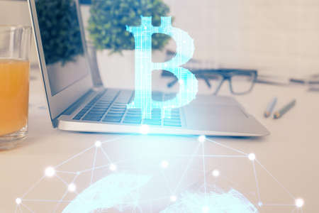 Double exposure of blockchain theme hologram and table with computer background. Concept of bitcoin crypto currency.の写真素材