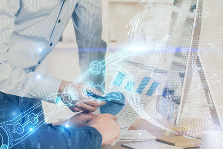 Technology theme hologram with man working on computer on background. High tech concept. Multi...