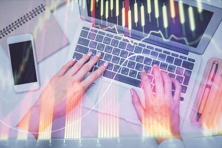 Double exposure of woman hands working on computer and forex graph hologram drawing. Top View....