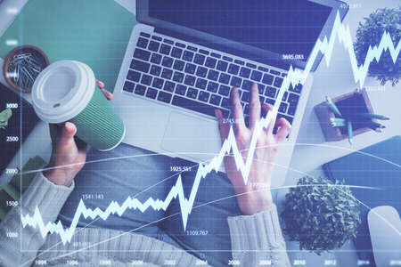 Double exposure of woman hands working on computer and forex chart hologram drawing. Top View....