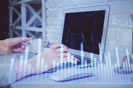 Double exposure of woman hands typing on computer and forex chart hologram drawing. Stock market...