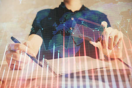 Double exposure of man hands holding a credit card and Forex graph drawing. Stock trading and...