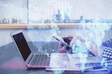 Double exposure of mans hands holding and using a digital device and forex graph drawing. Financial...