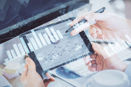Double exposure of mans hands holding and using a phone and financial chart drawing. Market analysis...