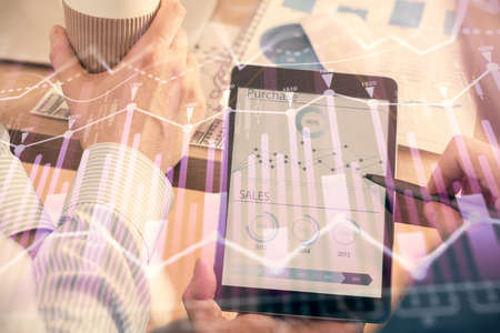 Double exposure of mans hands holding and using a phone and financial chart drawing. Market analysis...