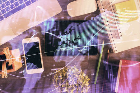 Double exposure of forex chart hologram over desktop with phone. Top view. Mobile trade platform concept.の写真素材