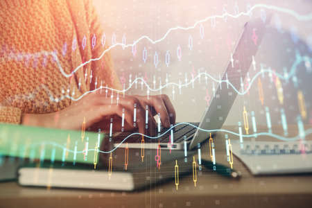 Double exposure of woman hands typing on computer and forex chart hologram drawing. Stock market...