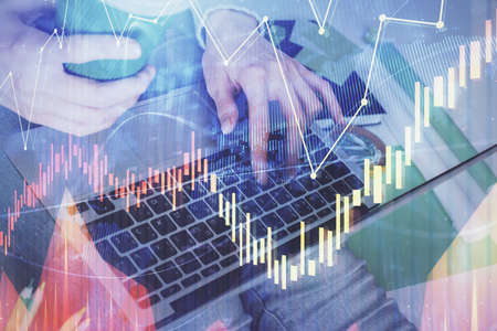 Double exposure of woman hands typing on computer and forex chart hologram drawing. Stock market invest concept.の写真素材