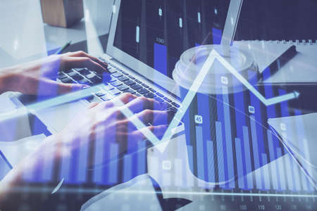 Double exposure of woman hands typing on computer and forex chart hologram drawing. Stock market...