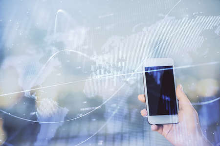 Double exposure of forex chart sketch hologram and woman holding and using a mobile device. Stock...
