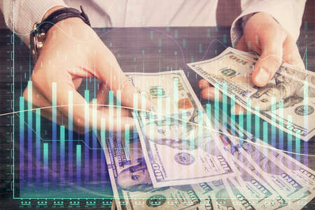 Multi exposure of financial graph drawing hologram and USA dollars bills and man hands. Analysis concept.の写真素材