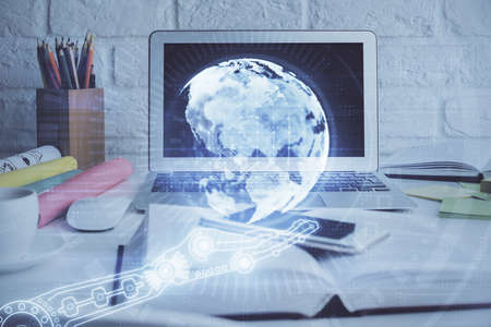 Double exposure of desktop with computer and world map hologram. International data network concept.