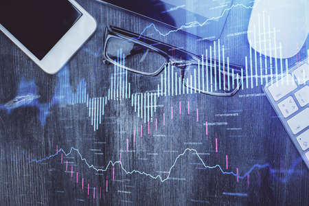 Multi exposure of forex graph hologram over desktop with phone. Top view. Mobile trade platform...