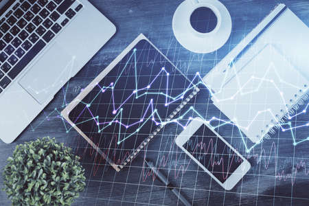 Double exposure of forex chart hologram over desktop with phone. Top view. Mobile trade platform concept.の写真素材