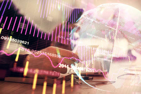 Double exposure of mans hands holding and using a phone and financial graph drawing. Analysis...
