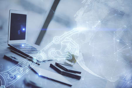 Computer on desktop in office with technology theme hologram. Double exposure. Tech concept.