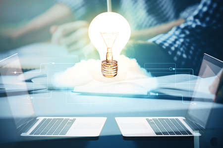 View of Bulb lamp idea concept icon on a futuristic interface with writing mans hand background....