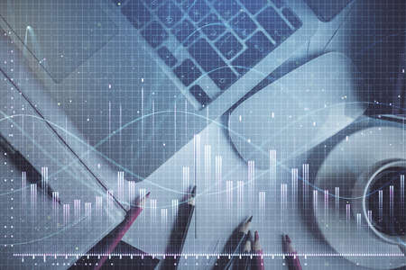 Double exposure of financial chart drawing over table background with computer. Concept of research...