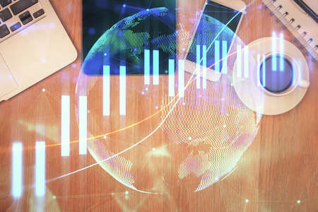 Double exposure of financial chart hologram over desktop with phone. Top view. Mobile trade platform...