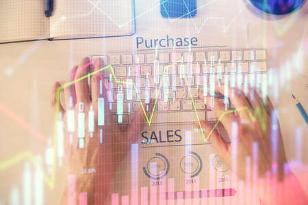 Double exposure of mans hands typing over laptop keyboard and forex chart hologram drawing. Top view. Financial markets concept.の写真素材