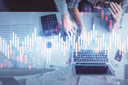Double exposure of man and woman working together and financial graph hologram drawing. market...