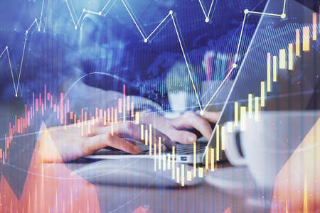 Double exposure of woman hands typing on computer and forex chart hologram drawing. Stock market...