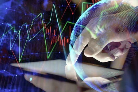 Double exposure of mans hands holding and using a digital device and forex graph drawing. Financial...
