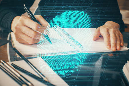 Blue fingerprint hologram over hands taking notes background. Concept of security. Double exposureの写真素材