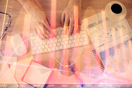 Multi exposure of mans hands typing over computer keyboard and forex graph hologram drawing. Top view. Financial markets concept.の写真素材