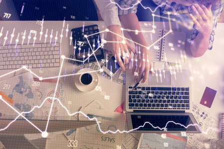 Double exposure of man and woman working together and financial graph hologram drawing. market...