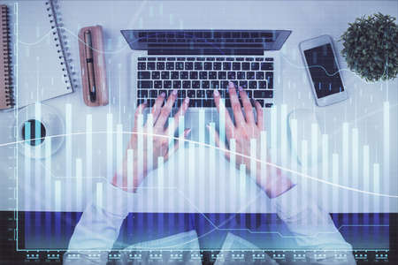 Double exposure of woman hands working on computer and forex chart hologram drawing. Top View....