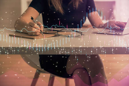 Double exposure of businesswoman hands typing on computer and forex chart hologram drawing. Financial analysis concept.の写真素材