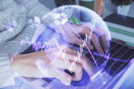 Double exposure of woman hands typing on computer and forex chart hologram drawing. Stock market...